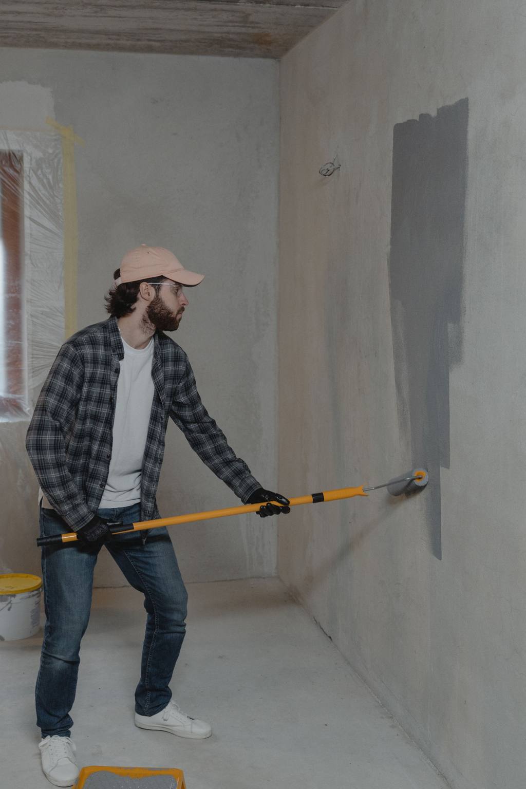 Decorator painting a wall with a roller